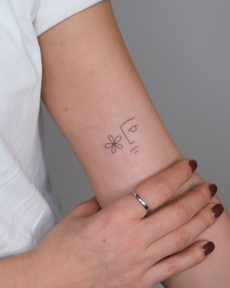 Minimalist face tattoo with floral elements
