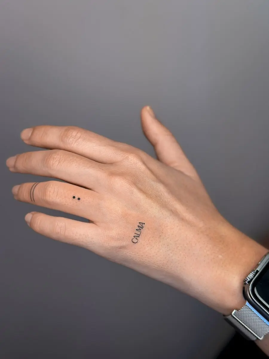 Minimalistic tattoo of the word 'Calma'