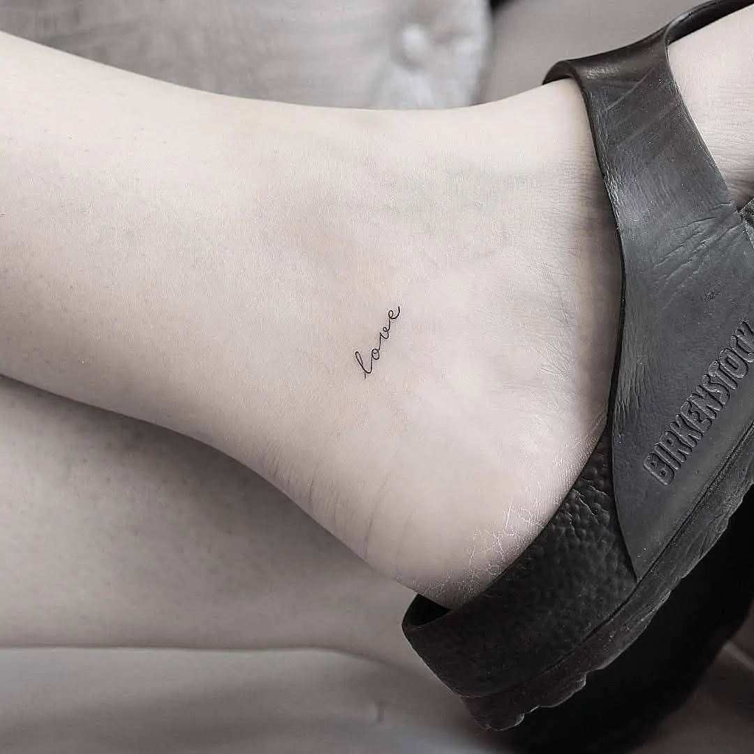 Delicate ankle tattoo showcasing the word 'love'