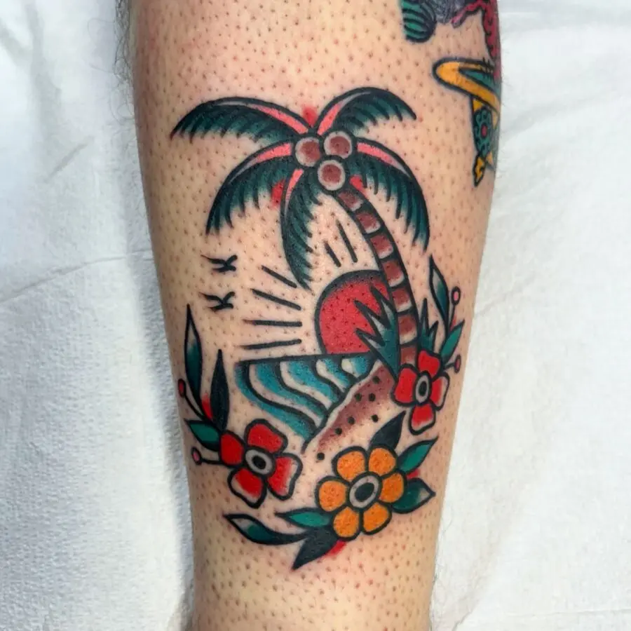 Vibrant palm tree tattoo with sunset and flowers