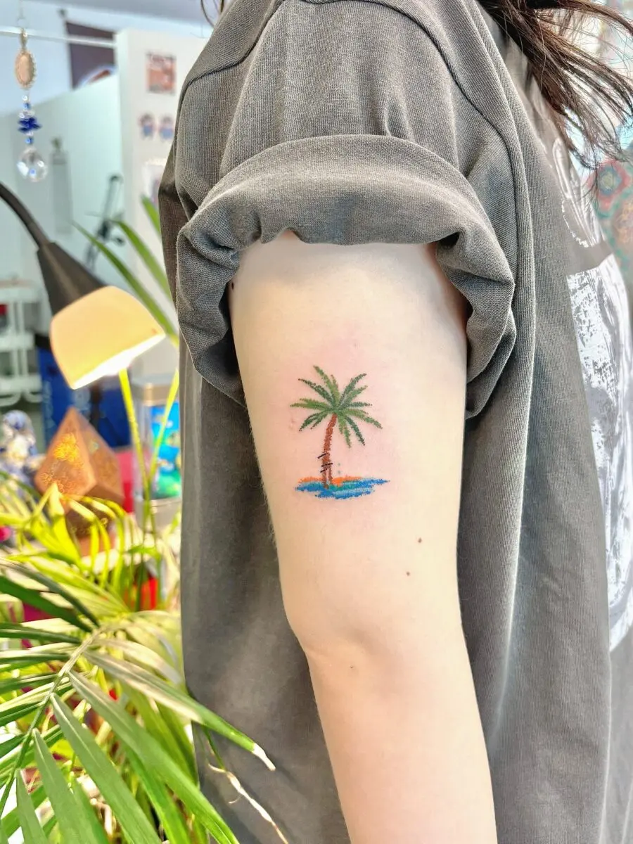 Charming palm tree tattoo on upper arm