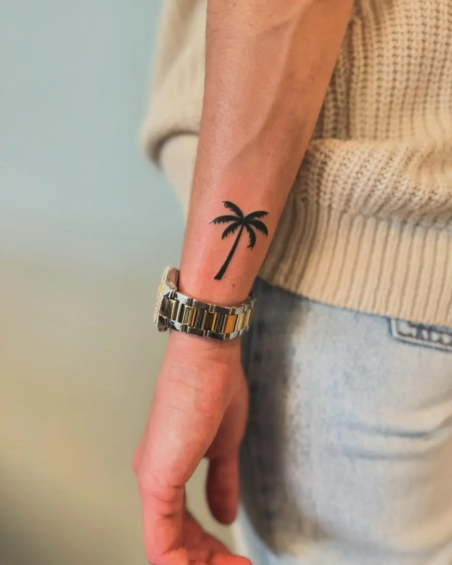 Minimalistic palm tree tattoo design on arm