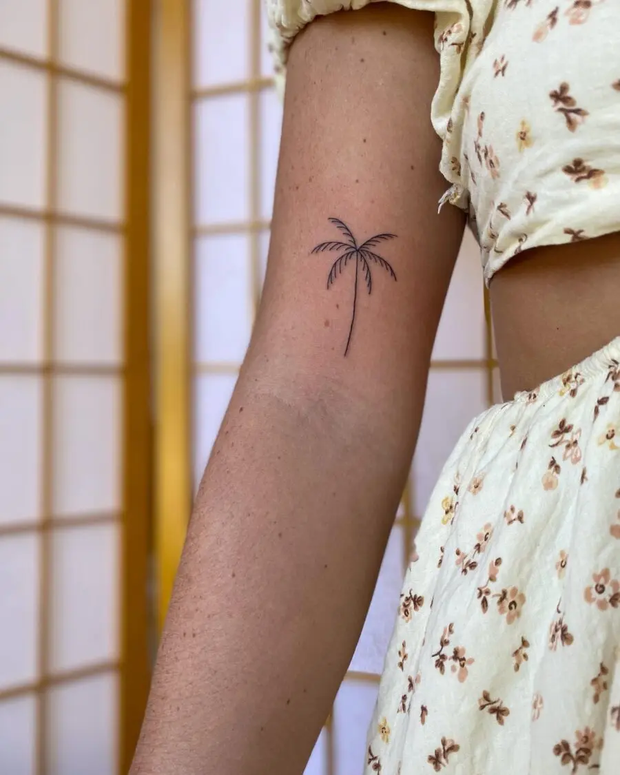 Elegant minimalist palm tree tattoo design.
