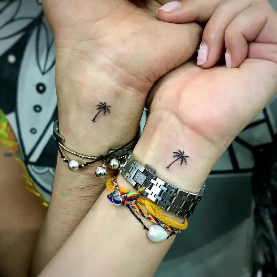 Minimalistic palm tree tattoos on wrists