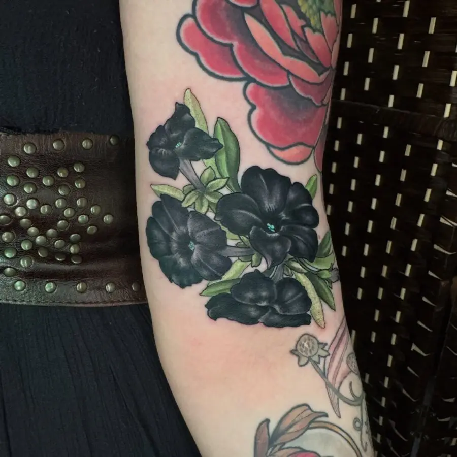 Stunning black petunia tattoo on the arm