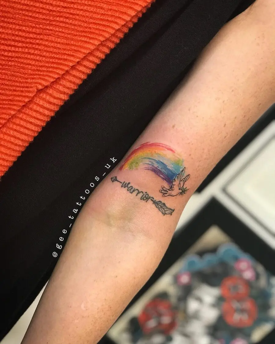 Vibrant rainbow baby tattoo with arrow design