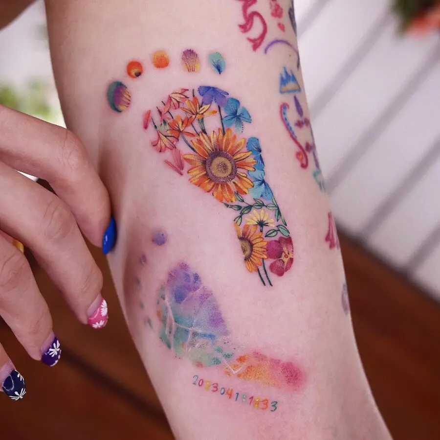 Vibrant rainbow baby footprints tattoo design