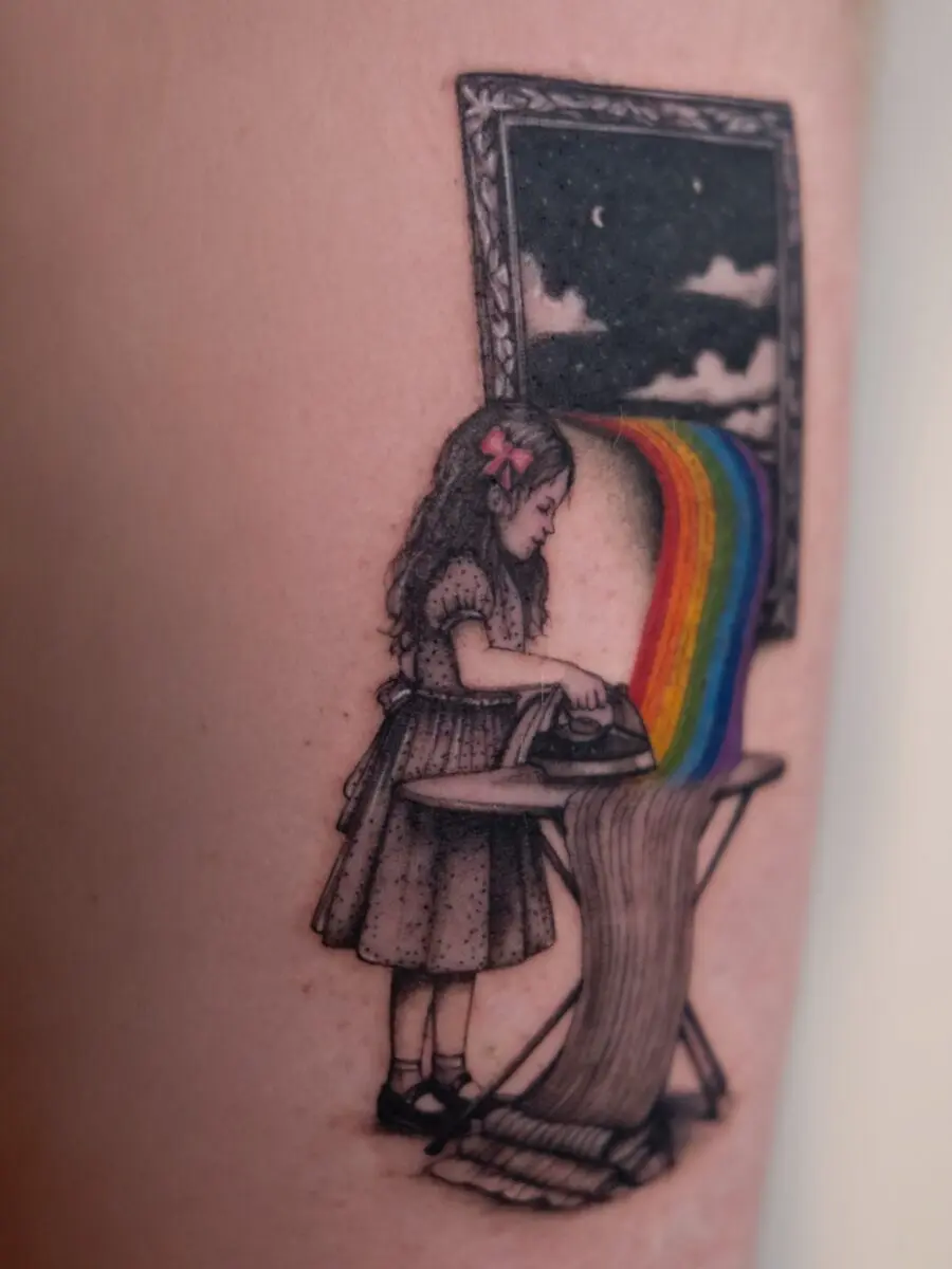 Charming girl ironing a vibrant rainbow tattoo