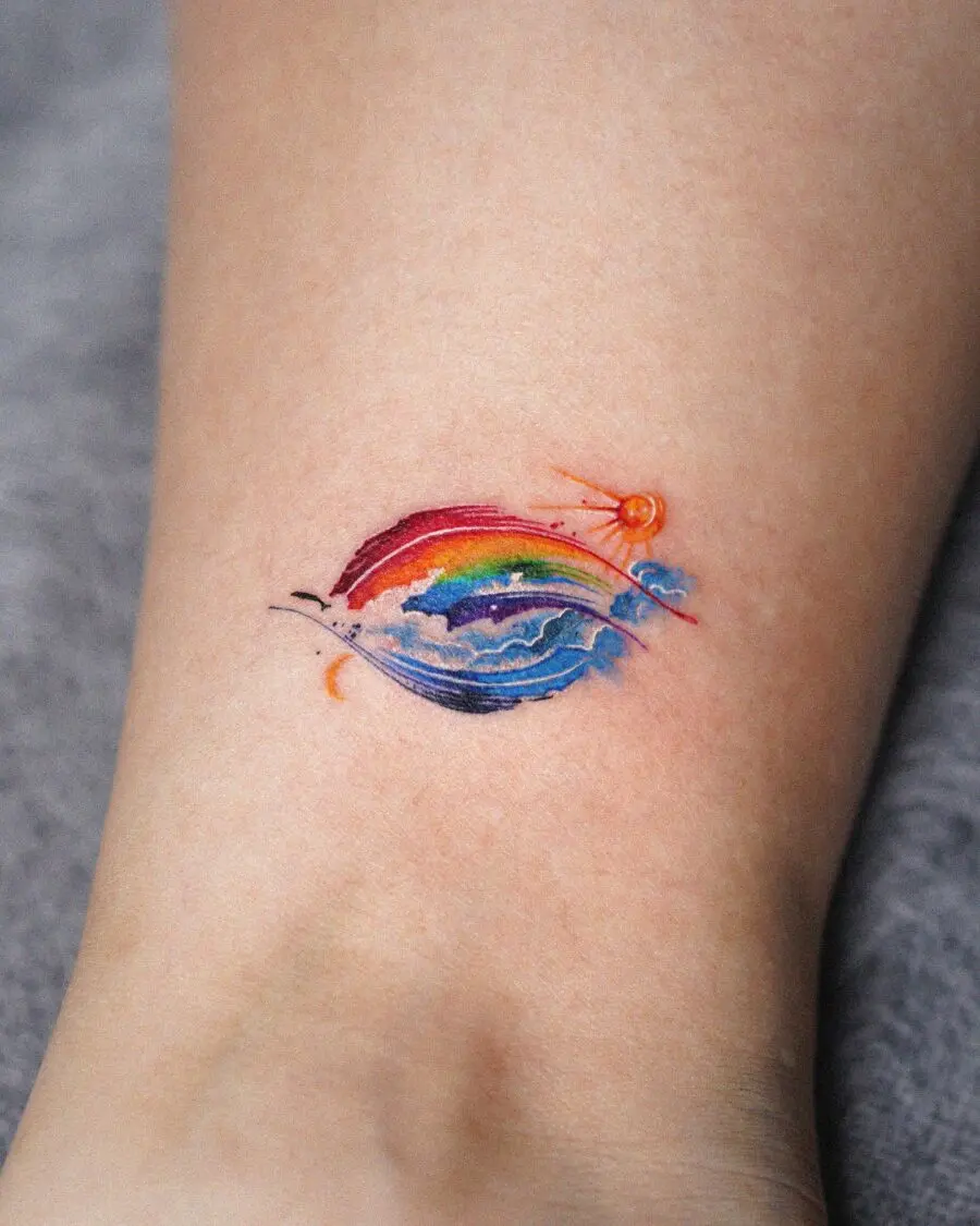 A vibrant rainbow baby tattoo with sun motif