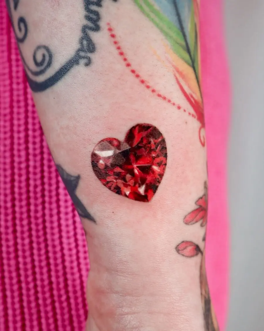 Vibrant red gemstone heart tattoo design