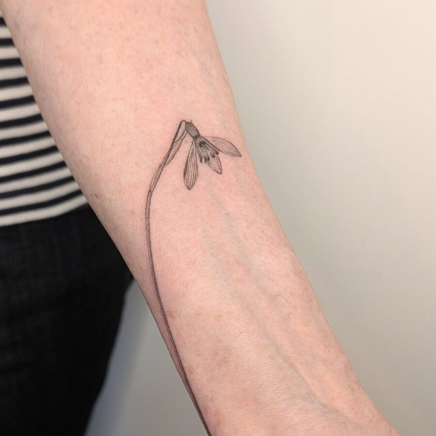 Elegant snowdrop tattoo on a delicate arm