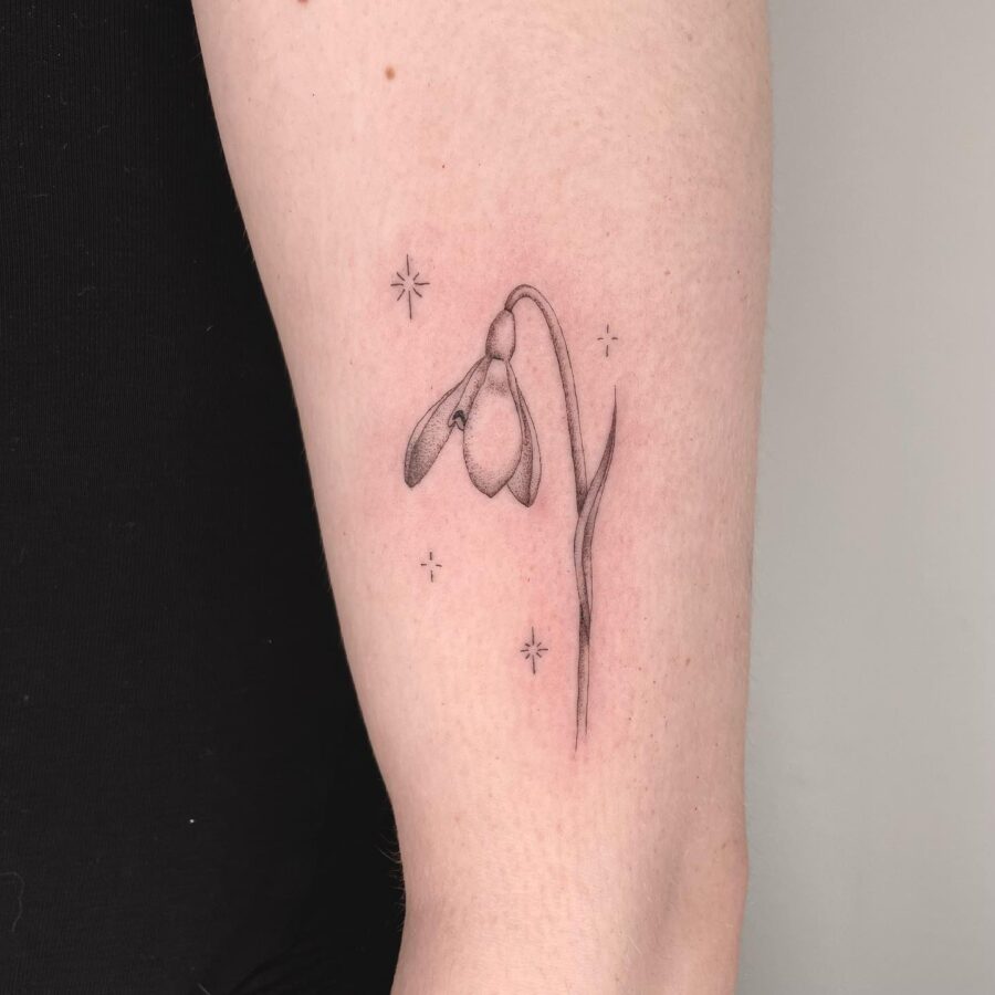 Elegant snowdrop tattoo with celestial accents