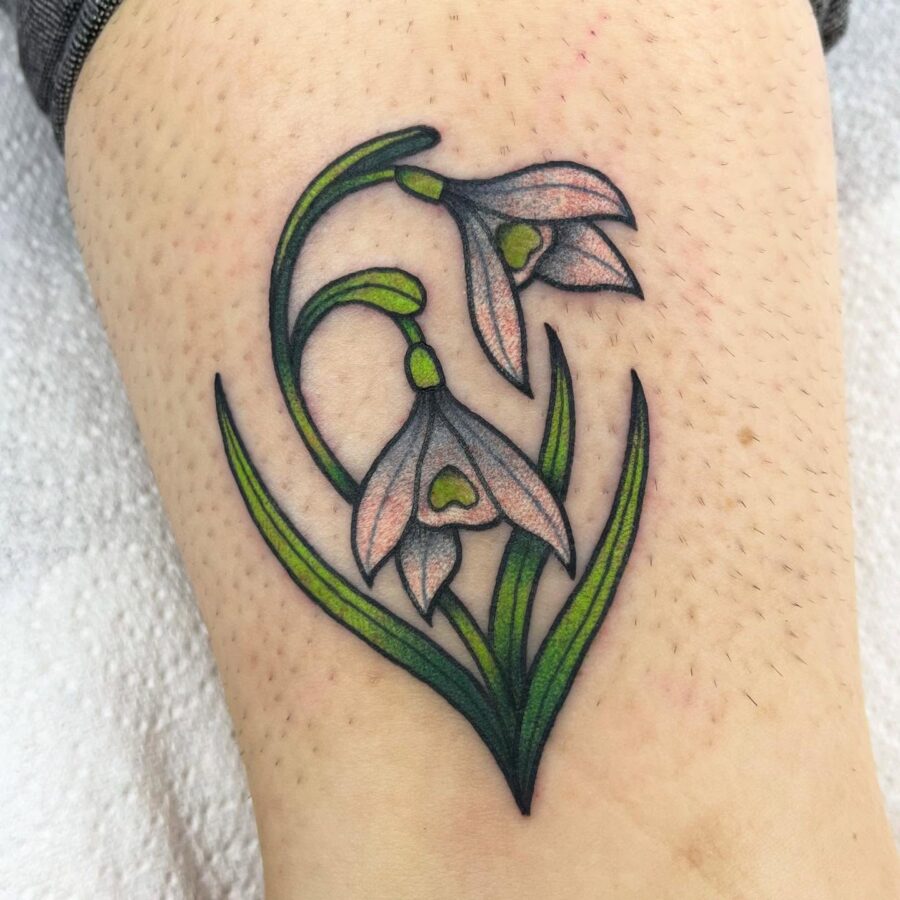 Delicate snowdrop tattoo with floral elegance