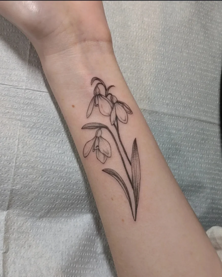 Elegant black ink snowdrop flower tattoo