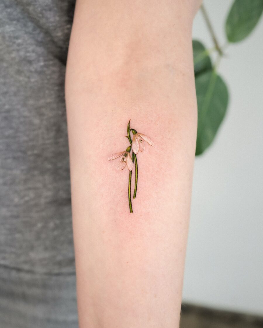 Delicate snowdrop tattoo on a forearm