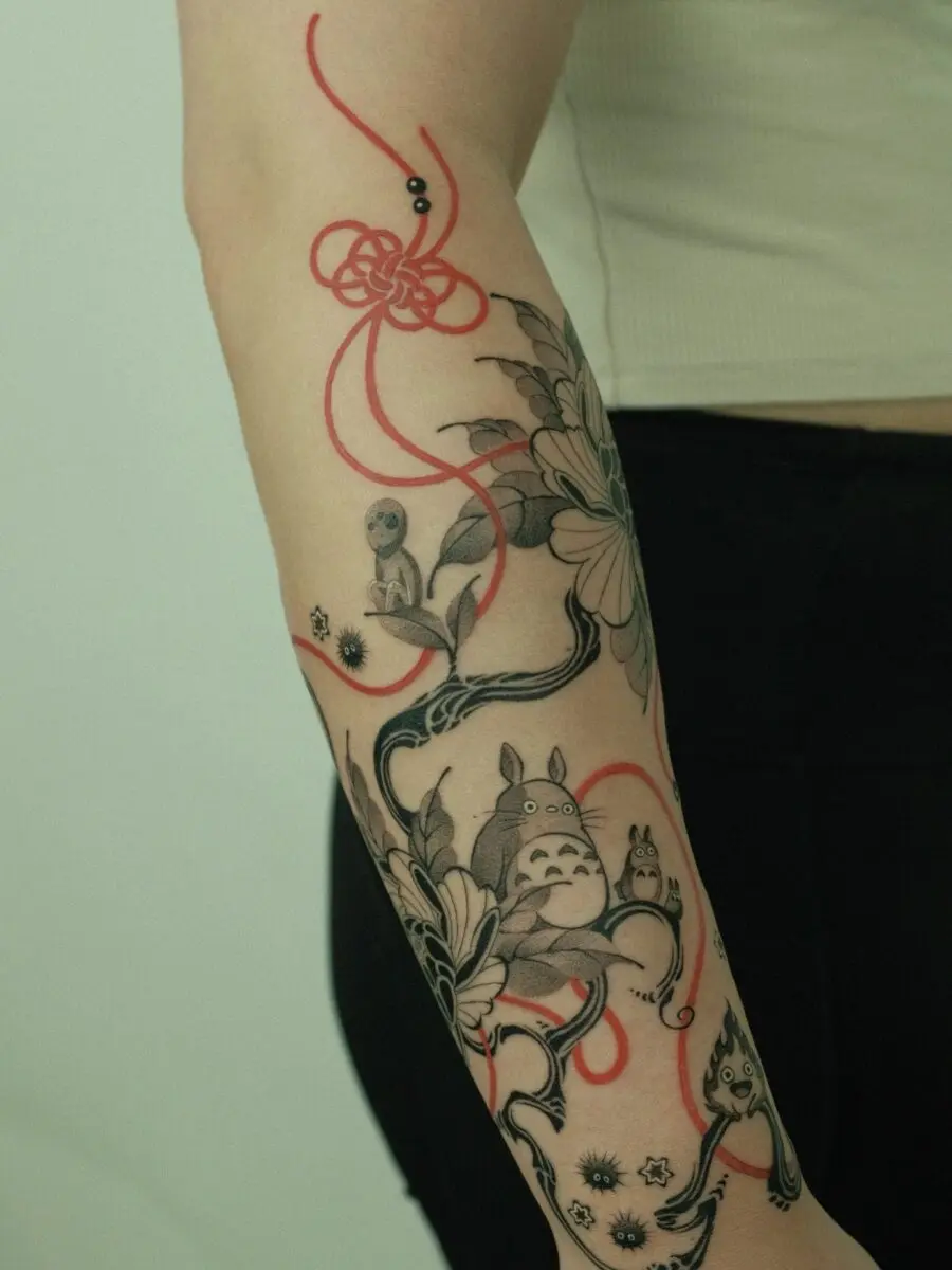 A whimsical Totoro tattoo design with flowers