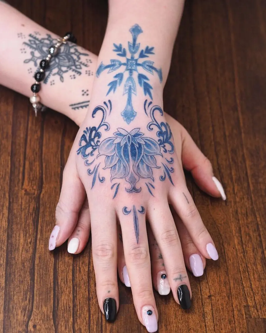 Elegant floral and cross tattoo design on hand