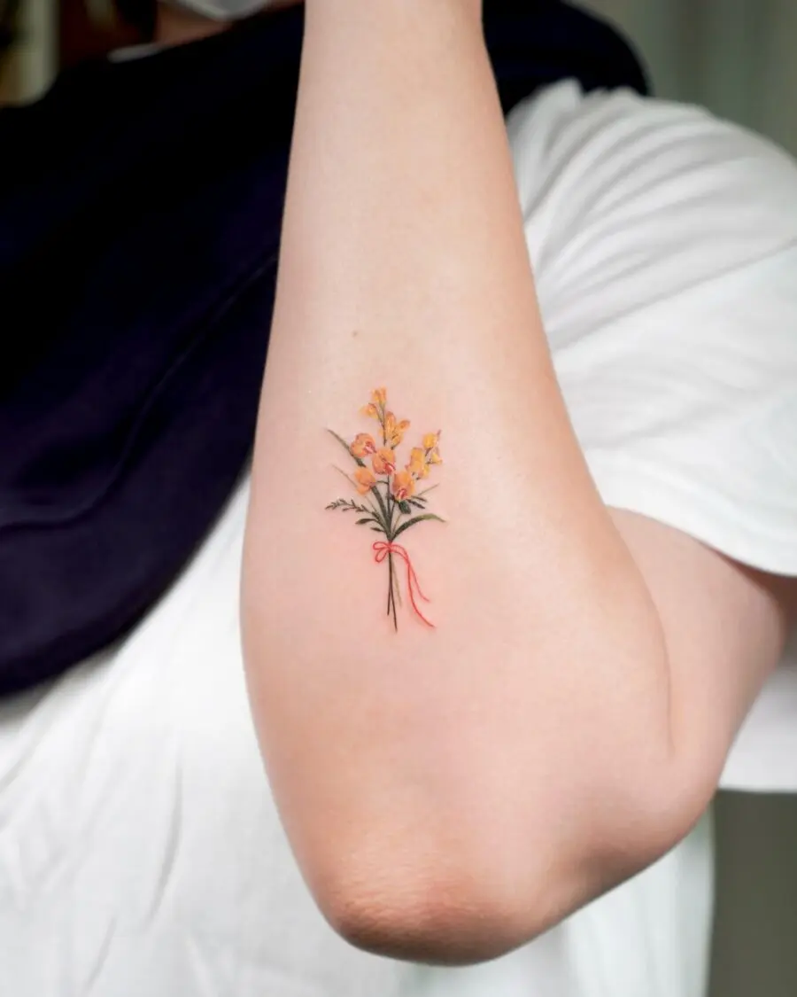 Colorful birth flower tattoo on the arm