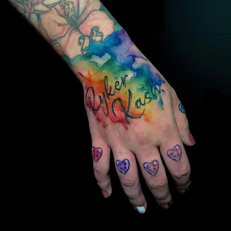 Vibrant rainbow baby tattoo on a hand.