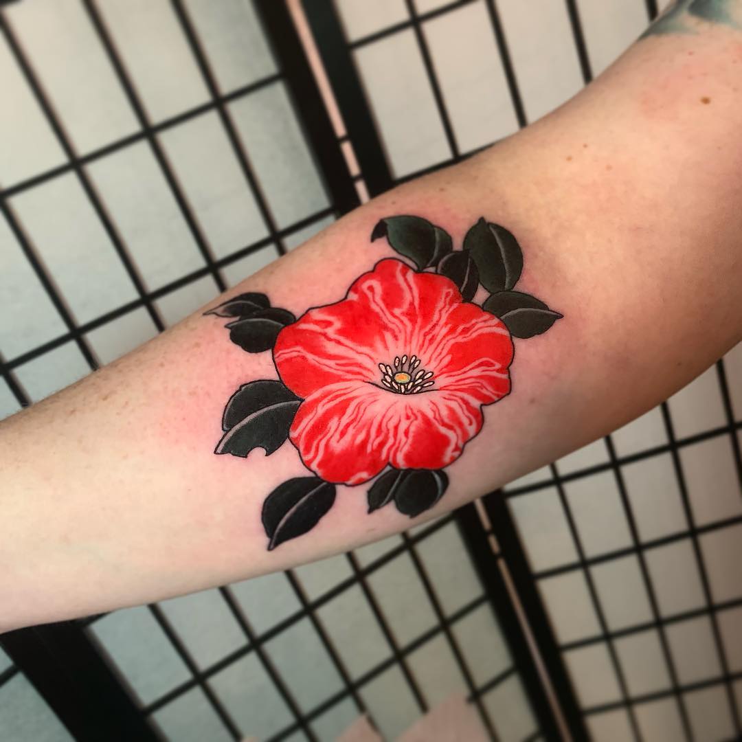 Vibrant red petunia tattoo with bold outlines