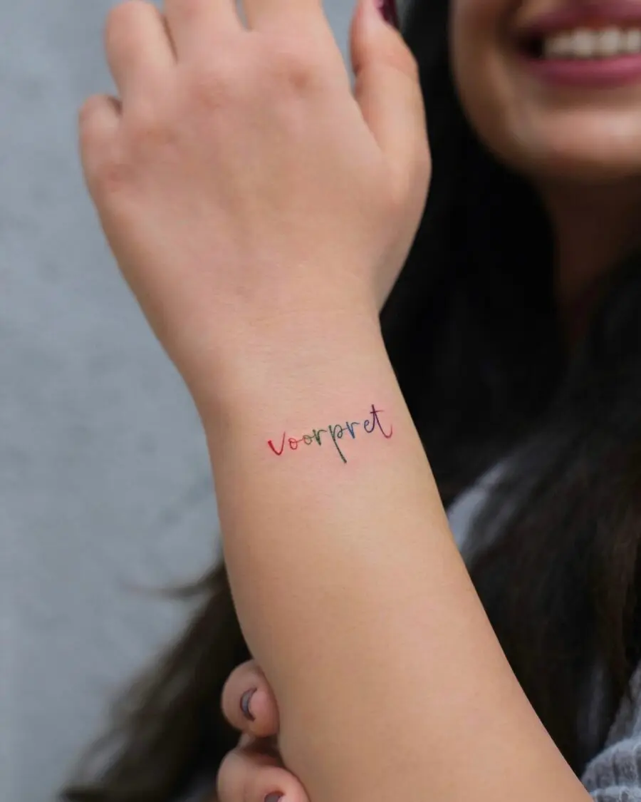 Colorful one-word tattoo on wrist