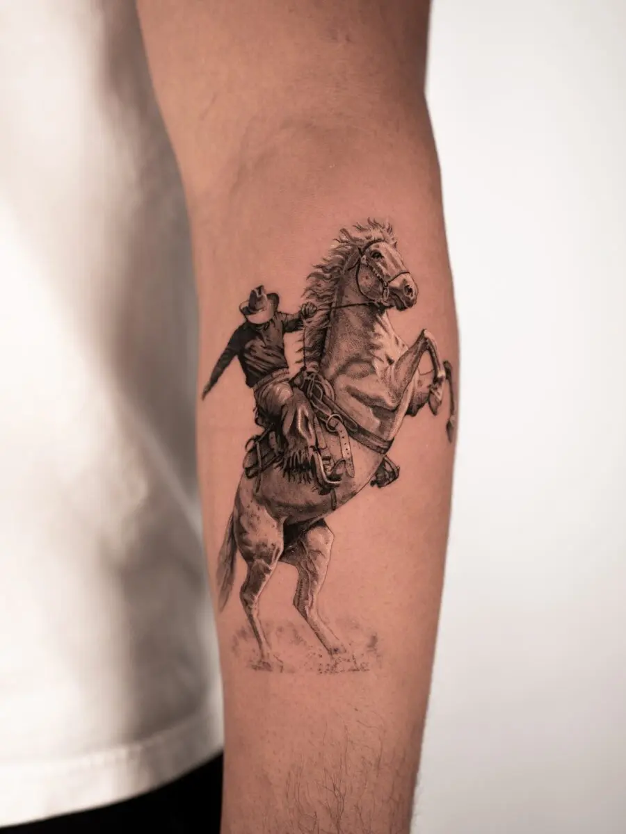 Dynamic cowboy riding a spirited horse tattoo