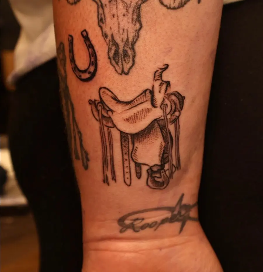 Intricate saddle tattoo with western motifs