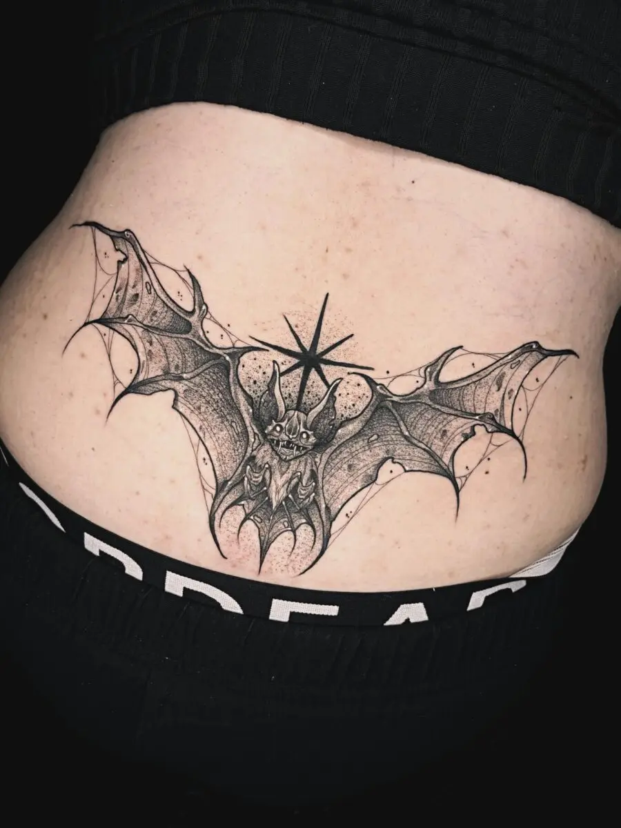 Intricate bat tattoo design on lower back