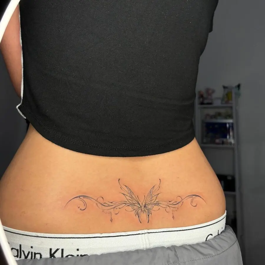 Elegant butterfly tramp stamp tattoo design showcased.