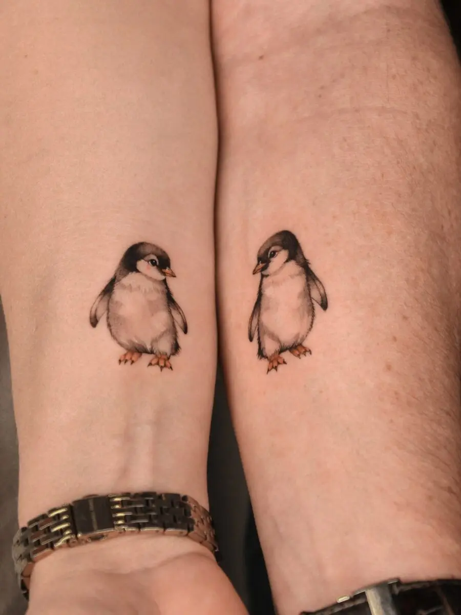 Adorable penguin tattoos capturing playful companionship