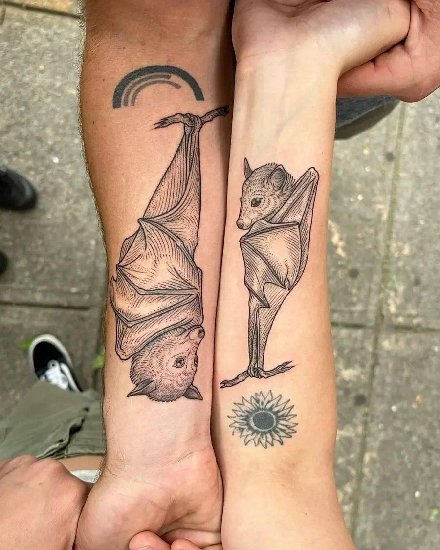 Unique bat couple tattoos with a sun design