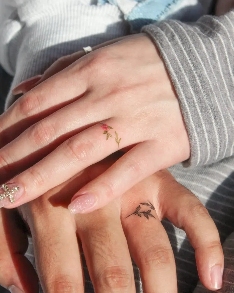 Delicate floral couple tattoos on hands