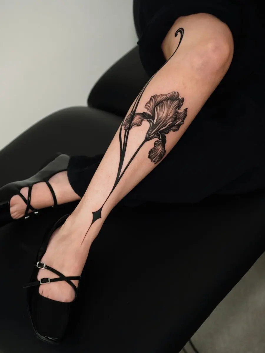 Elegant black floral tattoo on the leg