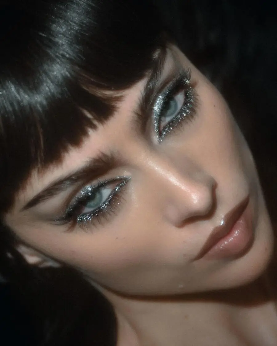 Striking dark feminine makeup with silver accents