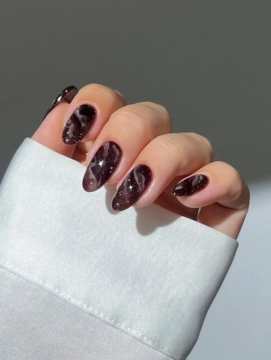 Glossy dark nails with sparkly accents