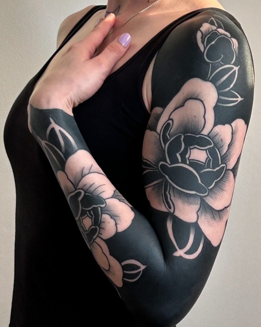 Elegant black and blush floral arm tattoo