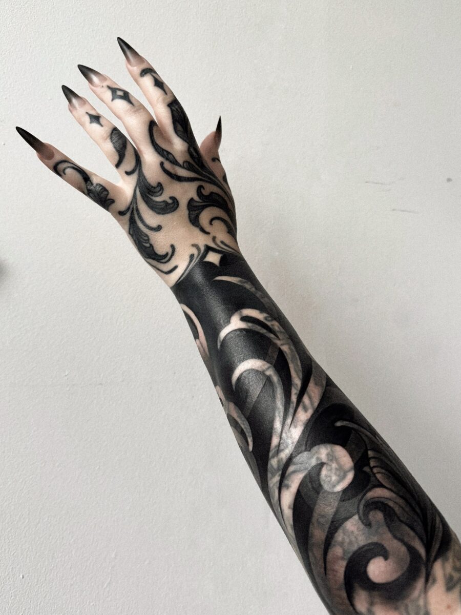 Intricate dark feminine tattoos on the arm
