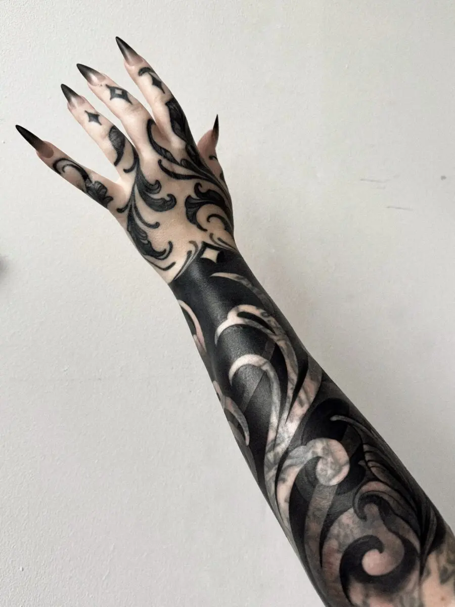 Intricate dark feminine tattoos on the arm