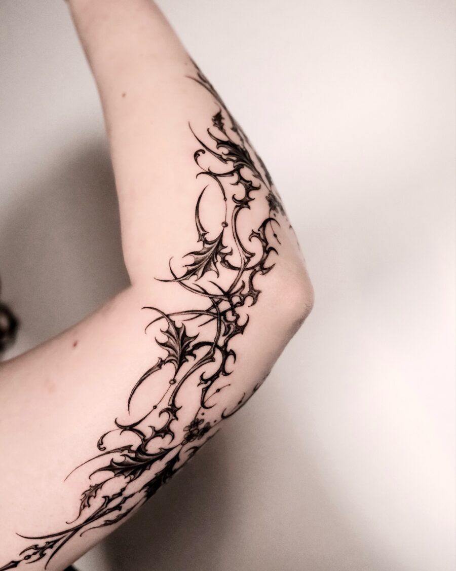 Intricate batwing floral arm tattoo design