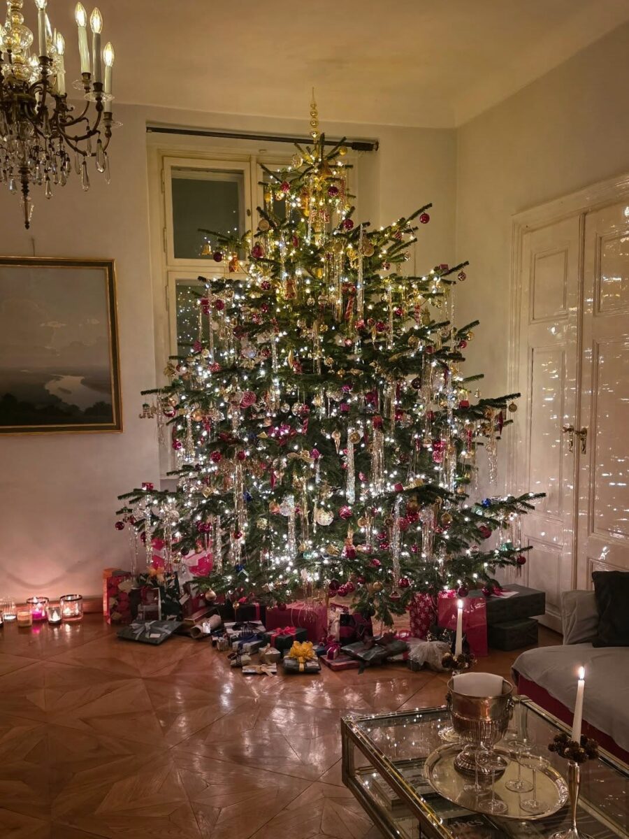 Elegant Christmas tree surrounded by warmly lit gifts