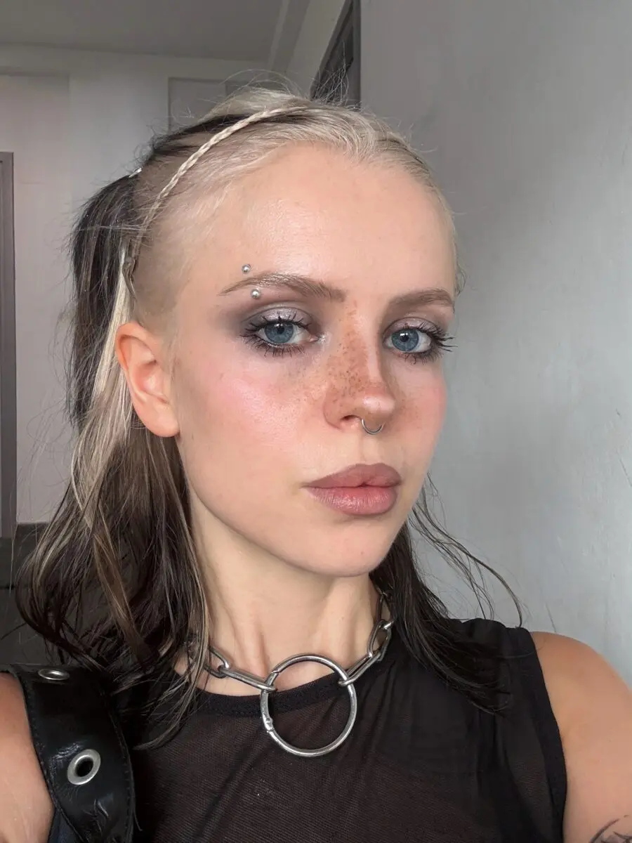 Shimmering emo look with striking piercings