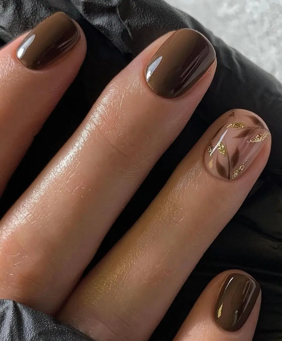 Elegant brown nails with golden leaf design