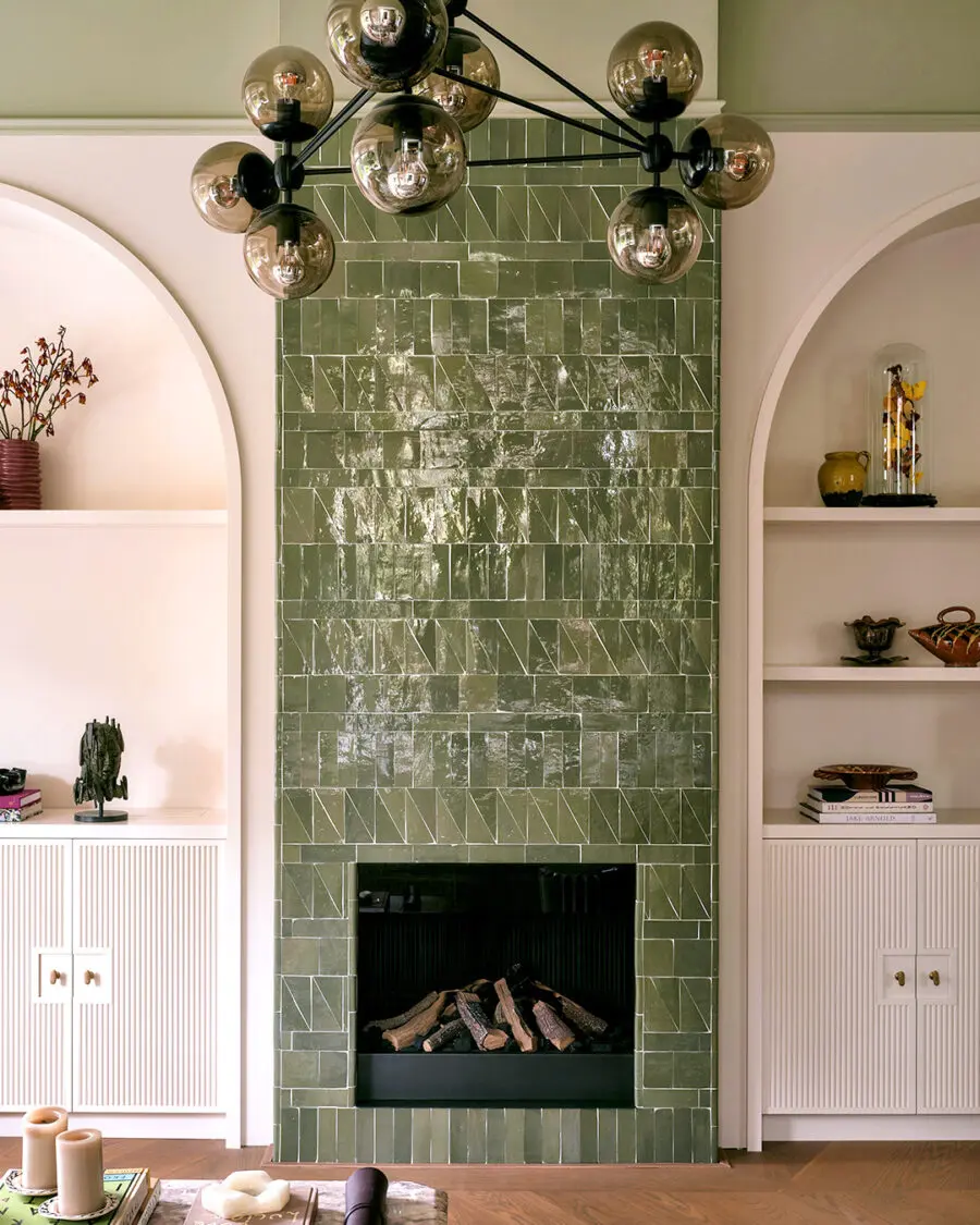 Elegant green-tiled fireplace enhances cozy vibes