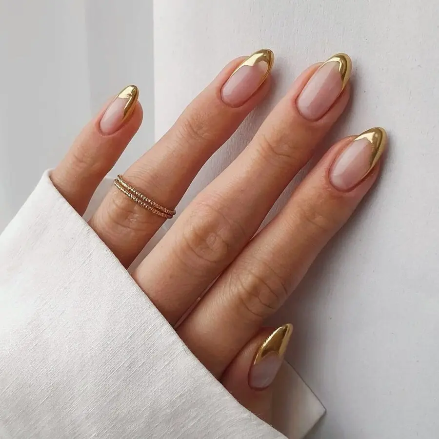 Sleek gold-tip almond-shaped nails shine elegantly