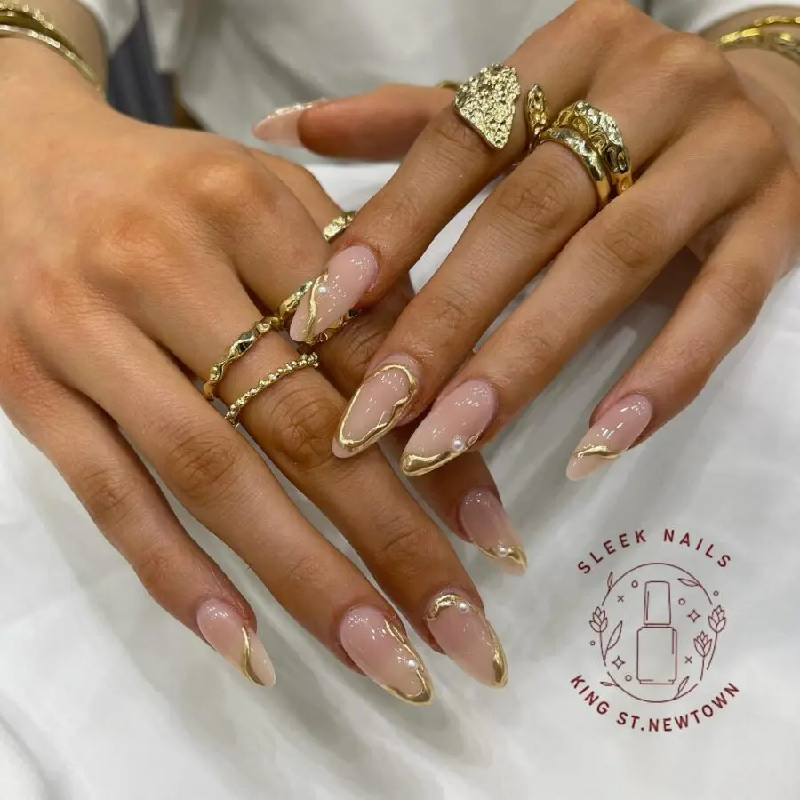 Chic gold-tipped nails with gemstone rings