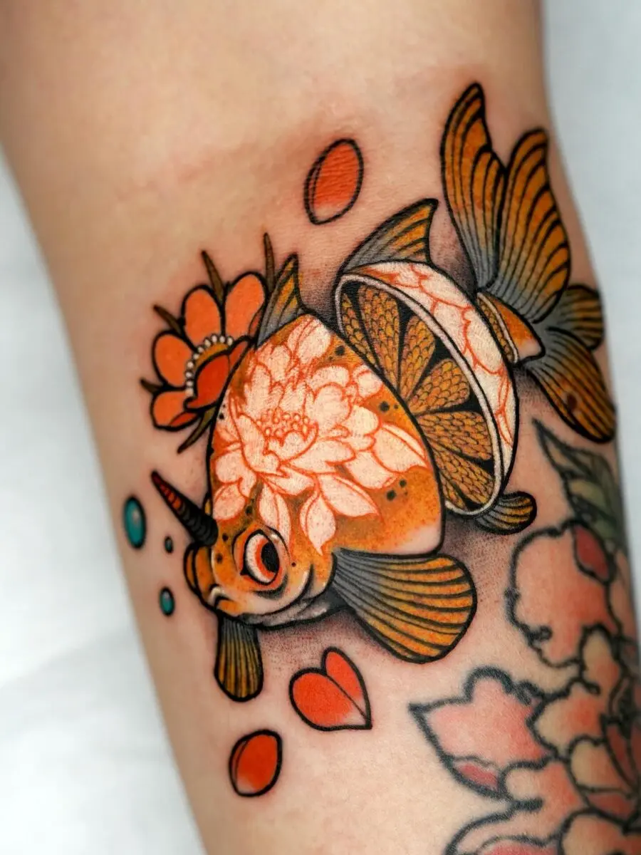 Whimsical goldfish tattoo with floral accents