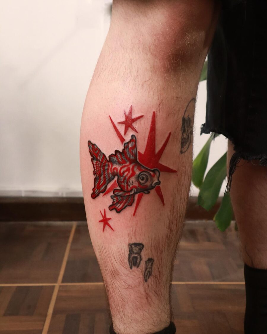 Vibrant Red Ink Goldfish Tattoo with Stars
