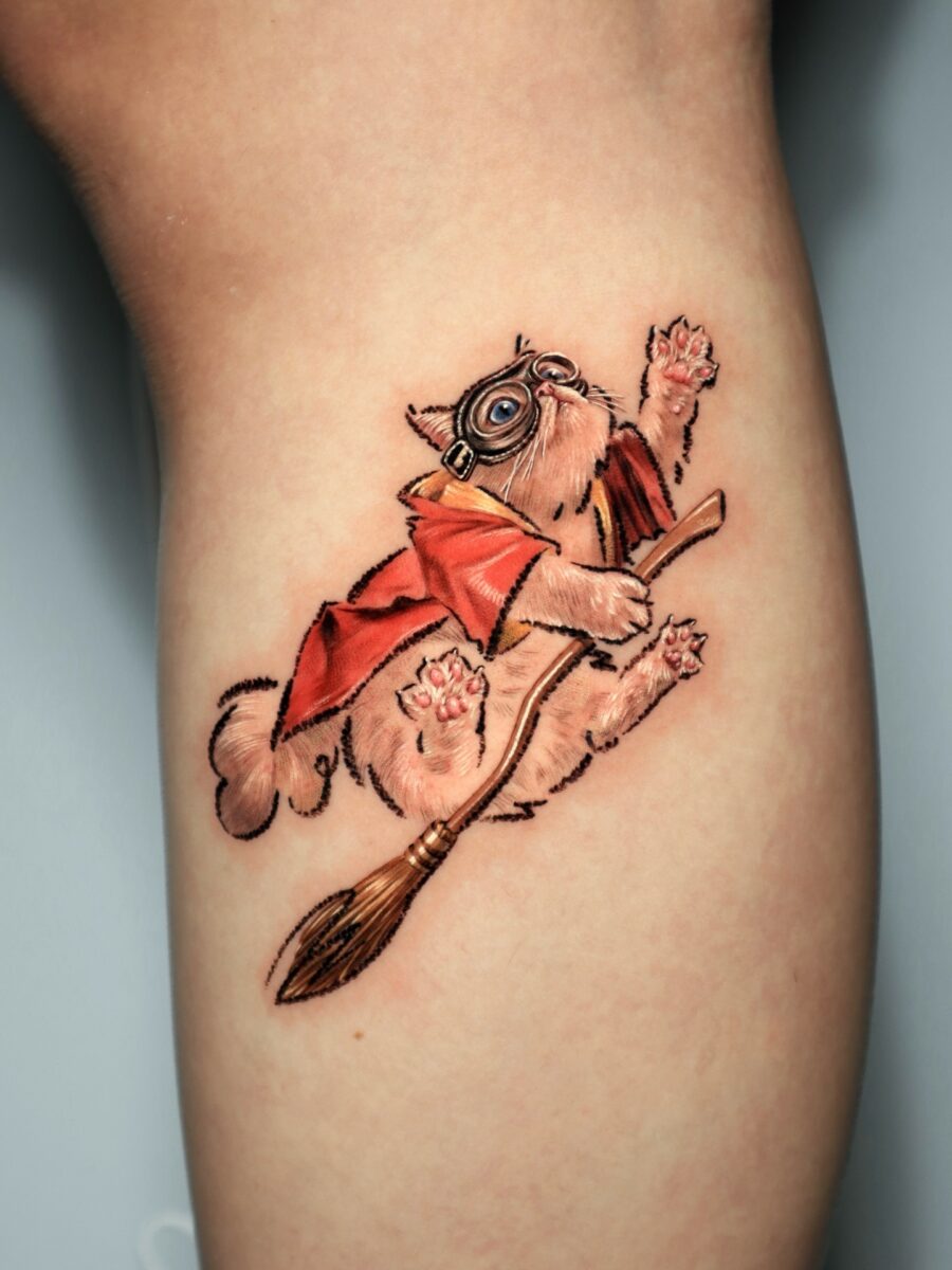 Whimsical feline on a flying broomstick tattoo