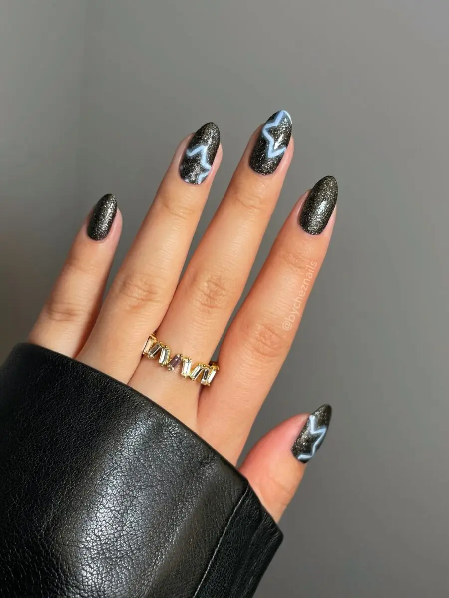 Shimmering black nails with starry accents