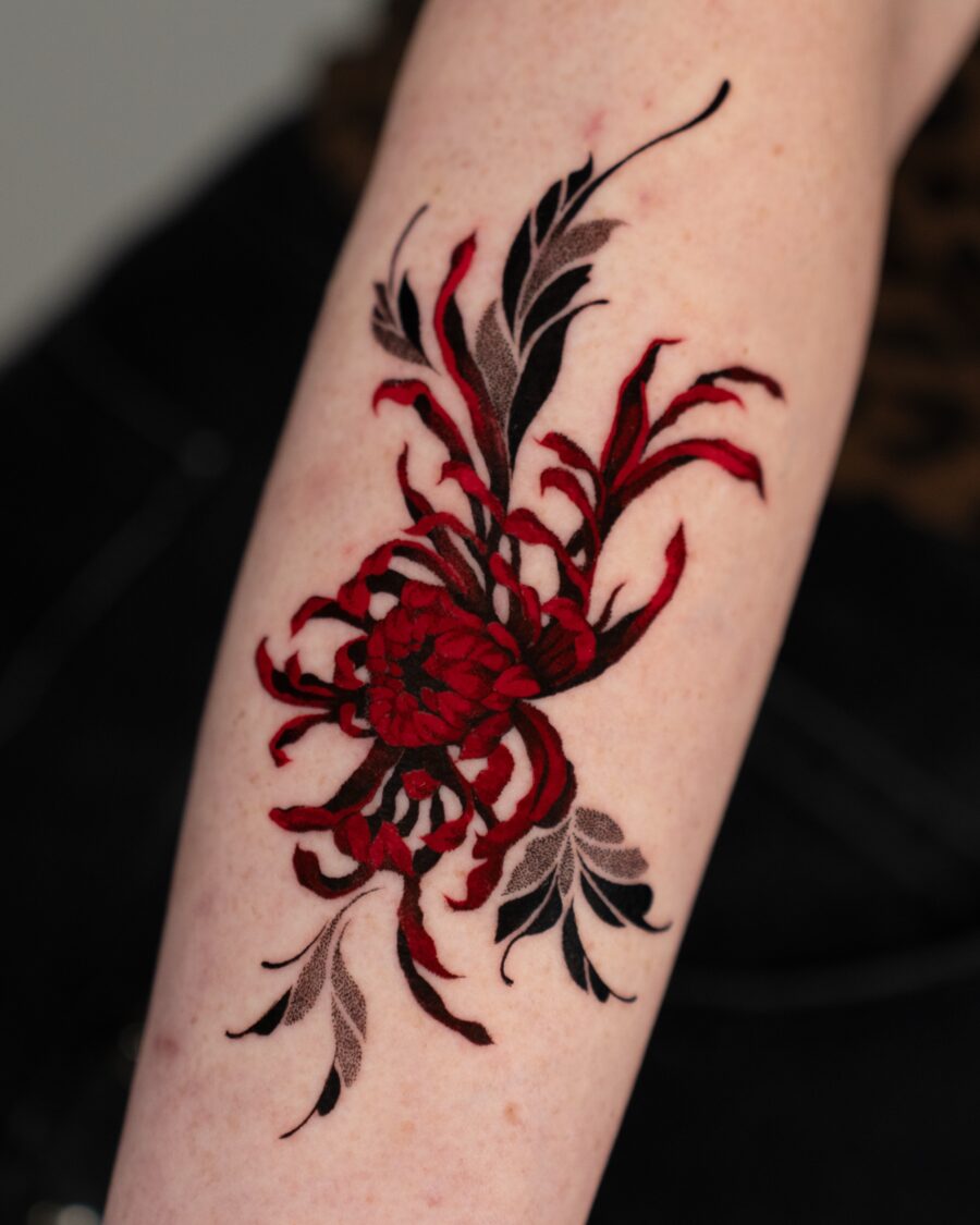 Intricate red floral design tattoo on arm